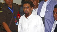 Militan Muslim Indonesia Hisyam bin Alizein, atau dikenal dengan Umar Patek, pembuat bom dalam tragedi Bom Bali, dikawal oleh jaksa dan petugas polisi saat ia meninggalkan ruang sidang di Pengadilan Negeri Jakarta Barat di Jakarta, Senin (21/5/2012). Pada 6 November 2002 10 orang yang diduga ikut terlibat dalam pengeboman ditangkap di sejumlah tempat di Pulau Jawa. (AP Photo/Tatan Syuflana).