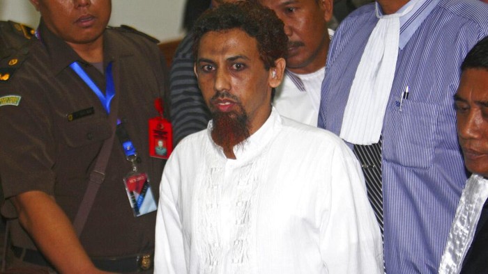 Militan Muslim Indonesia Hisyam bin Alizein, atau dikenal dengan Umar Patek, pembuat bom dalam tragedi Bom Bali, dikawal oleh jaksa dan petugas polisi saat ia meninggalkan ruang sidang di Pengadilan Negeri Jakarta Barat di Jakarta, Senin (21/5/2012).