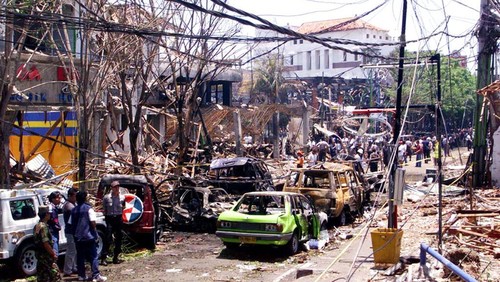 Orang-orang melihat lokasi pemboman di sebuah klub malam di Denpasar, Bali.