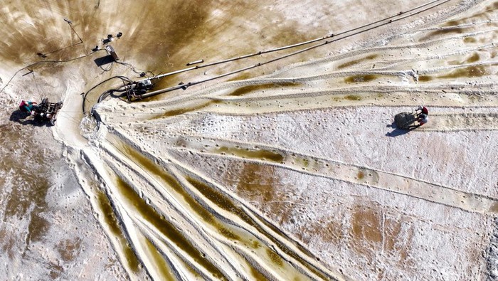 Mengintip Panen Garam di China, Sama Nggak Kayak di RI? LIANYUNGANG, CHINA - OCTOBER 12: Workers harvest crude salt at a salt farm on October 12, 2022 in Lianyungang, Jiangsu Province of China. (Photo by VCG/VCG via Getty Images)