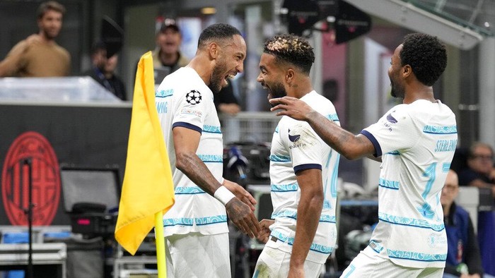 Chelseas Pierre-Emerick Aubameyang, left, celebrates with Reece James and Raheem Sterling, right, after scoring his sides second goal during the Champions League group E soccer match between AC Milan and Chelsea at the San Siro stadium in Milan, Italy, Tuesday, Oct. 11, 2022. (AP Photo/Antonio Calanni)