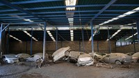 Mobil-mobil tampak bertumpukan setelah diterjang banjir bandang di sebuah pabrik perakitan kendaraan di Las Tejerias, negara bagian Aragua, Venezuela, Senin, (10/10/2022).