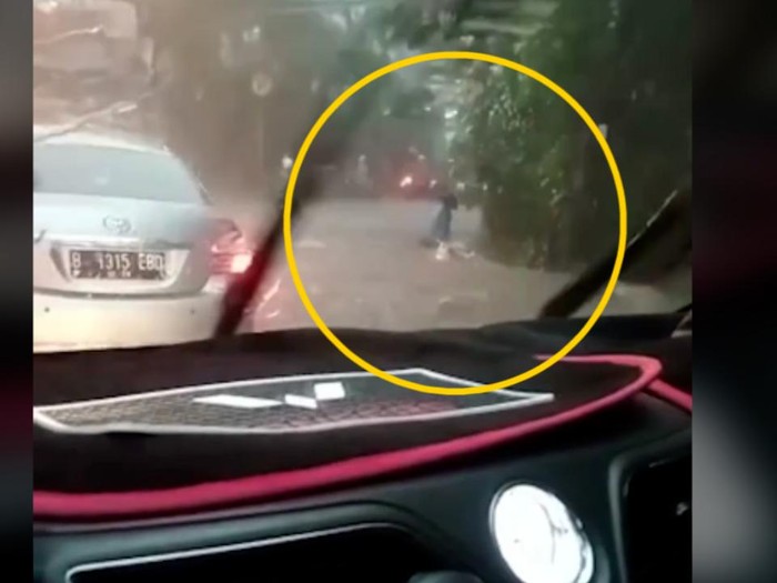 Seorang pemotor wanita terekam kamera jatuh ke gorong-gorong usai terseret arus banjir di Bogor. Hingga saat ini korban belum ditemukan.