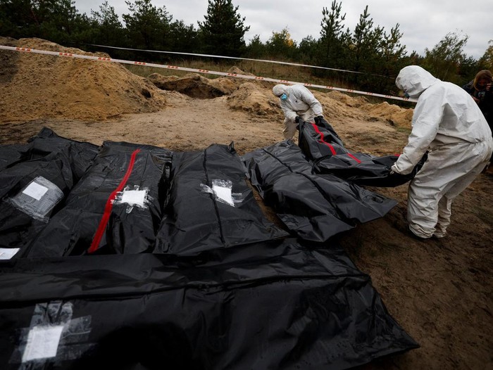 Forensics lie down a body of an army officer they exhumed from, what Ukrainians said, a mass grave, amid Russias invasion of Ukraine, in the newly recaptured town of Lyman, Donetsk region, Ukraine, October 11, 2022. REUTERS/Zohra Bensemra