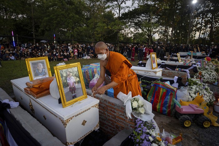 Seorang biksu menyiapkan peti mati berisi korban untuk kremasi di kuil Wat Rat Samakee di Uthai Sawan, Thailand, Selasa (11/10/2022). Puluhan tungku ini dibangun untuk mengkremasi jazad para korban pembantaian di tempat penitipan anak yang terjadi pada Kamis (6/10).