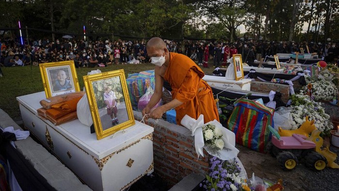 Potret Kremasi 24 Anak Korban Pembantaian di Thailand Seorang biksu menyiapkan peti mati berisi korban untuk kremasi di kuil Wat Rat Samakee di Uthai Sawan, Thailand, Selasa (11/10/2022). Puluhan tungku ini dibangun untuk mengkremasi jazad para korban pembantaian di tempat penitipan anak yang terjadi pada Kamis (6/10).