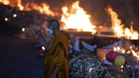 Seorang biksu berdoa saat proses kremasi jenazah korban di kuil Wat Rat Samakee di Uthai Sawan, Thailand, Selasa (11/10/2022). Tersangka kasus ini adalah seorang mantan polisi, yang diidentifikasi sebagai Panya Khamrapm.   