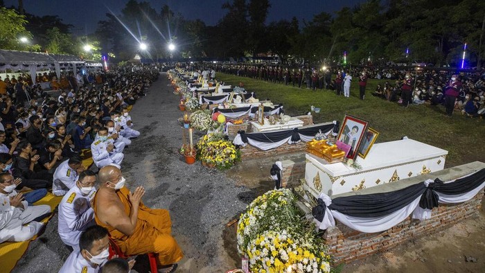 Potret Kremasi 24 Anak Korban Pembantaian di Thailand Sederet peti mati berisi korban pembantaian di tempat penitipan anak tergeletak di atas tumpukan kayu bakar pemakaman di kuil Wat Rat Samakee di Uthai Sawan, Thailand, Selasa (11/10/2022) waktu setempat.