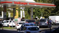 Seorang petugas polisi mengarahkan mobil saat pengemudi berbaris di sebuah pompa bensin di Paris. AP/Christophe Ena