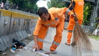 PPSU Kelurahan Gambir membersihkan sampah sisa demo buruh di patung kuda, Jakarta Pusat, Rabu (12/10/2022).