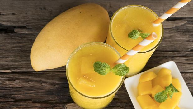 mango smoothies juice and ripe mango fruits. Yellow fruit on old wooden floor, drink in the morning to good health.