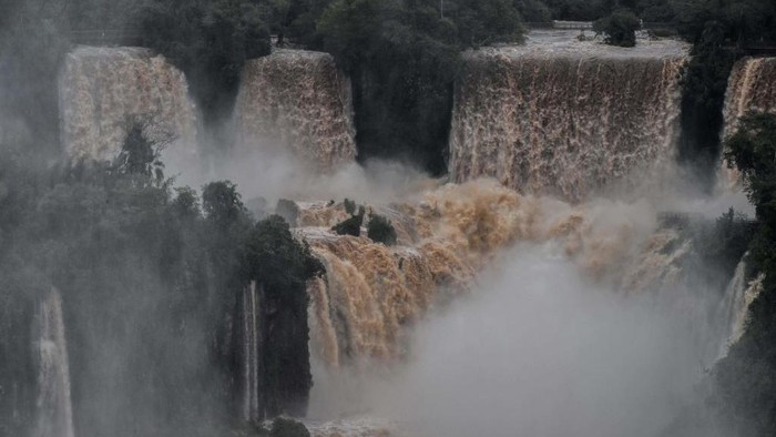 TOPSHOT - Picture of the Iguacu (Iguazu) falls -considered as one of the largest waterfalls in the world- as seen from the Brazilian side on the border with Argentina, near Foz do Iguacu, Parana state, Brazil on October 12, 2022. - The quantity of water falling from the Iguacu falls at the border between Argentina and Brazil has significantly increased in the last few days following heavy rains in the region. While the average flow rate of the falls is usually 1,5 million liters of water per second, the current rate is at 13.7 million. (Photo by NELSON ALMEIDA / AFP) (Photo by NELSON ALMEIDA/AFP via Getty Images)
