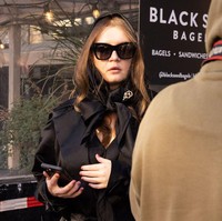 Sebuah aksesori yang menemani gayanya mencuri perhatian. Ia memakai scarf yang dihiasi bros dengan tulisan AD yang merupakan inisial dari Anna Delvey. (Foto: TIMOTHY A. CLARY/AFP via Getty Images)