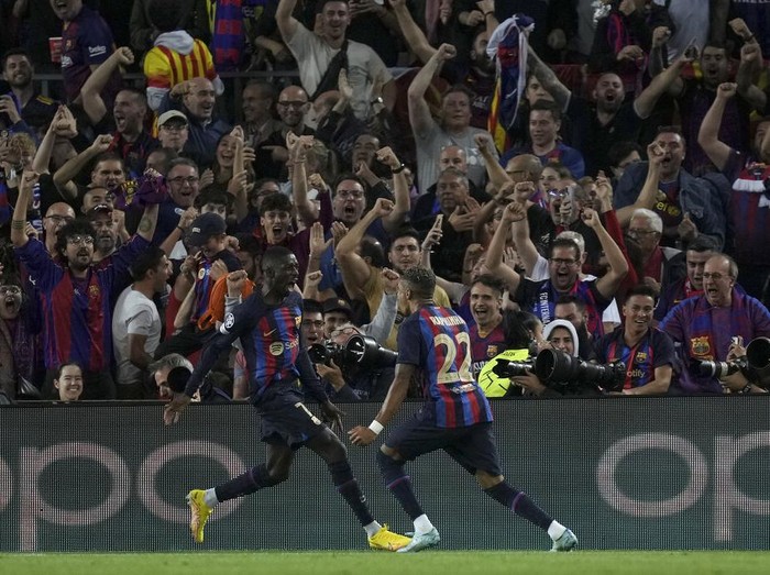 Barcelona's Ousmane Dembele, left, celebrates after scoring the opening goal during the Champions League Group C soccer match between Barcelona and Inter Milan at the Camp Nou stadium in Barcelona , Spain, Wednesday, Oct. 12, 2022. (AP Photo/Emilio Morenatti)
