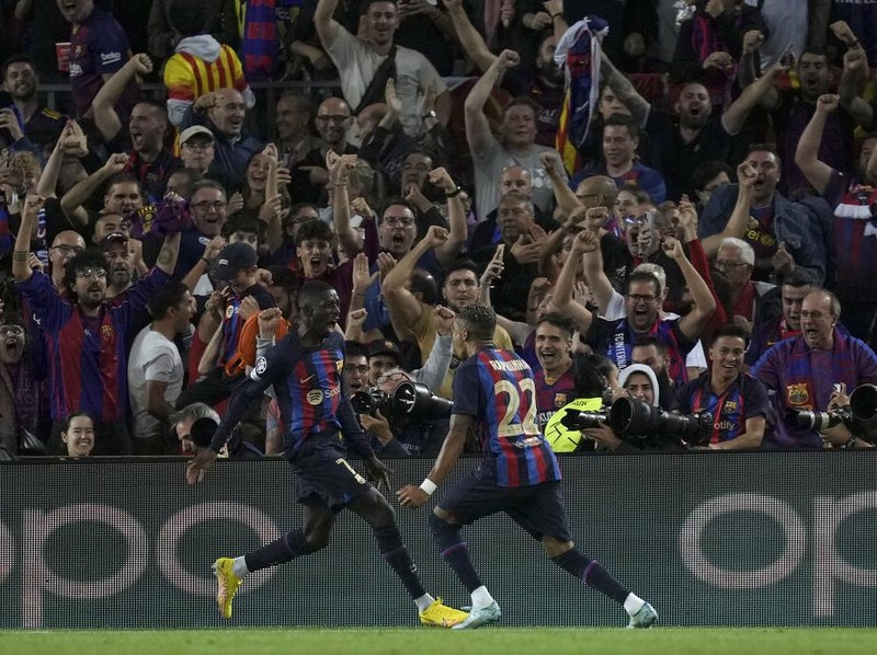 Barcelona's Ousmane Dembele, left, celebrates after scoring the opening goal during the Champions League Group C soccer match between Barcelona and Inter Milan at the Camp Nou stadium in Barcelona , Spain, Wednesday, Oct. 12, 2022. (AP Photo/Emilio Morenatti)