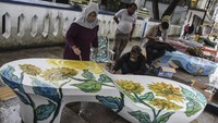 Istri Wali Kota Tasikmalaya sekaligus seniman perupa Rukmini Yusuf (kiri) melukis di kelom geulis raksasa di Pedestrian HZ Mustofa, Kota Tasikmalaya, Jawa Barat, Kamis (13/10/2022).