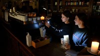 Karyawan menyiapkan kopi di sebuah kafe tanpa listrik di kota Lviv, Ukraina barat, setelah tiga rudal Rusia menembakkan infrastruktur energi yang ditargetkan. Wali Kota Lviv mengatakan sepertiga rumah penduduk yang ada kini tanpa listrik usai serangan rudal Rusia. Yuriy Dyachyshyn/AFP/Getty Images.