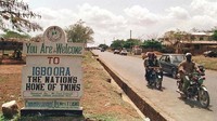 Papan bertuliskan kata sambutan terlihat di pintu masuk kota Igbo-Ora, barat daya Nigeria, menyambut orang-orang ke Pusat Anak Kembar di Dunia. Kota tenang ini dikenal sebagai tempat dengan jumlah penduduk kembar terbanyak sedunia. (Pius Otomi Ekpei/AFP/Getty Images)  