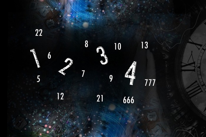 Hand holds a clock on the background of space and numerology