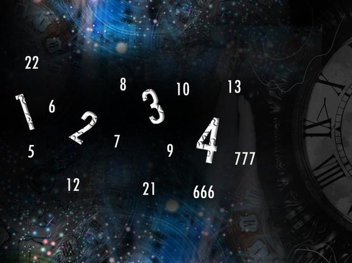 Hand holds a clock on the background of space and numerology
