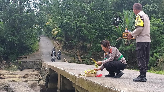 Kapolsek Kerambitan AKP Ni Komang Sri Subakti melakukan upacara mapekeling dengan harapan segera ada kepastian terkait keberadaan korban hanyut di Yeh Ho, Tabanan, Jumat (14/10/2022).