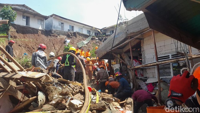 Tim SAR gabungan melanjutkan proses evakuasi tiga orang yang masih tertimbun longsor di Gang Barjo, Kota Bogor. Satu korban ditemukan meninggal dunia. (M Sholihin/detikcom)