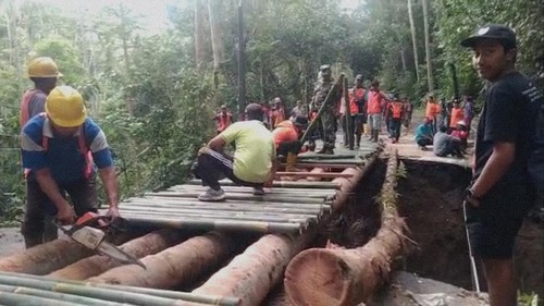 Warga gotong royong membangun jembatan darurat di jalan jebol akibat hujan deras di bawah Pasar Desa Yangapi, Kecamatan Tembuku, Kabupaten Bangli. (Dok. Camat Tembuku)