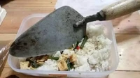 Lupa membawa alat makan untuk menikmati bekalnya, netizen ini pilih alat ekstrem untuk menyantapnya. Sendok semen yang bahkan lebih besar dari wadah bekalnya digunakan untuk menyuapkan nasi bekal ke dalam mulut. Foto: Reddit