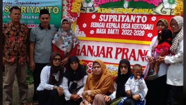 Warga berfoto bersama di depan karangan bunga dari Ganjar.