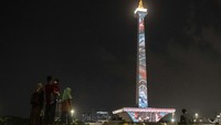 Pengunjung menyaksikan pertunjukkan video mapping pada acara Monas Week 2022 di kawasan Monas, Jakarta, Jumat (14/10/2022). 