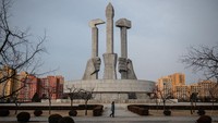 Seorang wanita berjalan melewati Monumen Yayasan Partai Buruh Korea di Pyongyang, Korea Utara. (Carl Court/Getty Images)