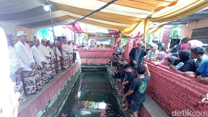 Ritual pengangkatan batang kayu di Situs Balong Keramat Pangeran Mancur Jaya, Desa Kertawinangun, Kecamatan Kedawung, Kabupaten Cirebon, Jawa Barat.