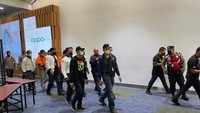 Ketiganya mengenakan baju tahanan berwarna oranye dengan masker menutupi mukanya (dok istimewa).
