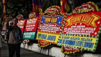Seorang warga melakukan swafoto di depan karangan bunga Anies Baswedan, Balai Kota, Jakarta, Minggu (16/10/2022). Anies Baswedan akan melakukan perpisahan hari ini dari jabatan Gubernur DKI Jakarta.