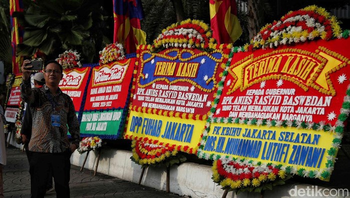 Aksi Warga Selfie dengan Karangan Bunga Perpisahan Anies Sejumlah warga melakukan swafoto di depan karangan bunga Anies Baswedan, Balai Kota, Jakarta, Minggu (16/10). Anies Baswedan akan melakukan perpisahan hari ini dari jabatan Gubernur DKI Jakarta.