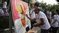 Seorang warga melukis karakter Anies di acara perpisahan Anies Baswedan dari jabatan gubernur.