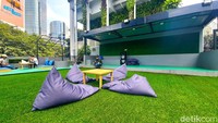 Hingga area bersantai menggunakan bean bag. Bahkan di dekat area bean bag ini terdapat semacam panggung yang bisa digunakan untuk live music. Jika sudah kehabisan ide hangout, maka kafe ini bisa jadi pilihan tepat. Luas, dekat, dan tentunya hijau.
