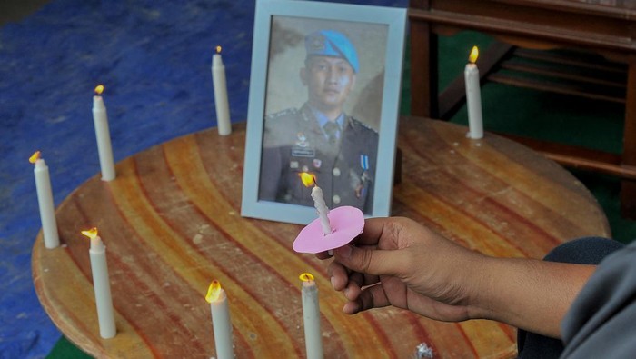 Pemuka agama menyalakan lilin disaksikan keluarga dan kuasa hukum mendiang Brigadir Nofriansyah Yosua Hutabarat atau Brigadir J saat mengenang 100 hari kematian Brigadir J di Sungai Bahar, Muarojambi, Jambi, Sabtu (15/10/2022).Memasuki 100 hari kepergian mediang, pihak keluarga berharap proses persidangan untuk kasus anaknya yang dijadwalkan digelar Senin (17/10/2022) dapat berjalan baik dan seadil-adilnya. ANTARA FOTO/Wahdi Septiawan/rwa.