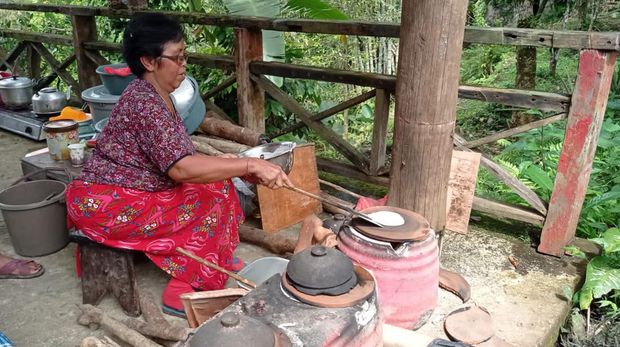 Nengah Murniati tengah membuat pesanan laklak beras merah di stand kuliner yang ada pada arena FCW Jatiluwih, Minggu (16/10/2022). (Istimewa)