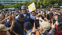 Anies yang meladeni ajakan berfoto juga berusaha keluar dari kerumunan warga sambil membawa sepeda miliknya.