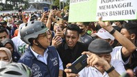 Anies membaca poster yang dibawa oleh warga saat bersepeda pada Hari Bebas Kendaraan Bermotor (HBKB) di kawasan Bundaran Hotel Indonesia (HI), Jakarta.