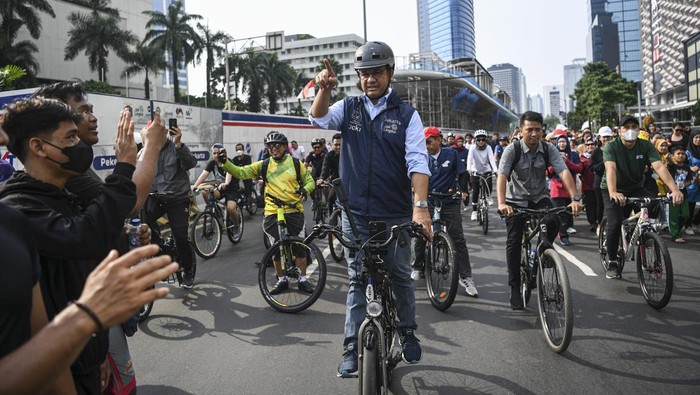 Gubernur DKI Jakarta Anies Baswedan (tengah) menyapa warga saat bersepeda pada Hari Bebas Kendaraan Bermotor (HBKB) di kawasan Bundaran Hotel Indonesia (HI), Jakarta, Minggu (16/10/2022). Kegiatan tersebut sebagai bentuk perpisahan dan berpamitan Anies Baswedan kepada warga Jakarta di hari terakhir menjabat sebagai Gubernur DKI Jakarta. ANTARA FOTO/M Risyal Hidayat/nym.
