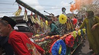 Warga mengikuti parade kendaraan yang dihiasi aneka barang sedekah saat perayaan Maulid Nabi Muhammad. Perayaan tersebut diisi dengan doa bersama.