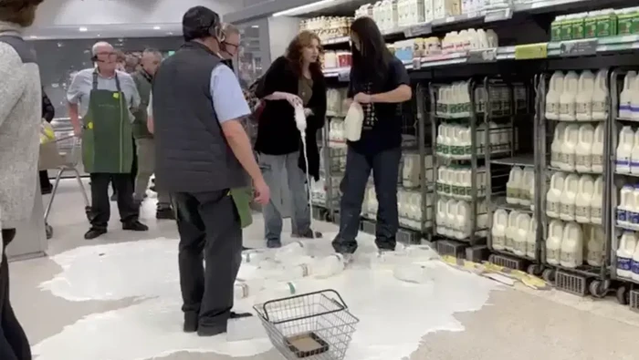 Aktivis Vegan membuang susu ke lantai supermarket sebagai aksi protes.