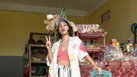 Andien berpose lucu di sebuah warung. Di belakangnya terlihat beberapa bungkus kerupuk dan aneka camilan. Foto: Instagram @andienaisyah