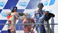 Pembalap Suzuki Ecstar Spanyol Alex Rins (kanan) dengan dan pebalap Ducati Lenovo Italia Francesco Bagnaia (tengah) dan pebalap Repsol Honda Spanyol Marc Marquez (kiri) merayakan di podium setelah menyelesaikan balapan MotoGP Australia. Paul Crock/AFP/Getty Images