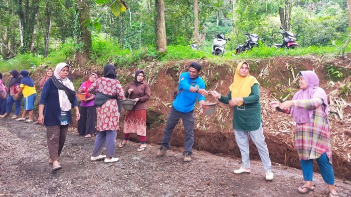 Warga bergotong royong perbaiki jalan rusak.