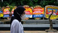Warga melintas di depan karangan bunga ucapan selamat untuk Heru Budi Hartono.