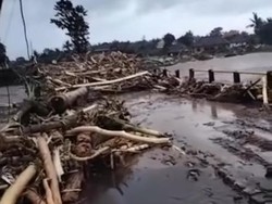 Jalur Denpasar-Gilimanuk di Kabupaten Jembrana ditutup sementara akibat banjir bandang yang membawa material seperti batang pohon hingga lumpur menutup akses jalan, Senin (17/10/2022). (Foto: Tangkapan layar)