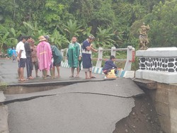 Jembatan putus akibat banjir bandang di Desa Penyaringan, Kecamatan Mendoyo, Kabupaten Jembrana, Bali, Senin (17/10/2022). Di lokasi itu pula, seorang siswa jatuh dan terseret arus. (Foto: I Ketut Suardika)